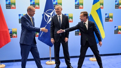 الرئيس التركي رجب طيب أردوغان ورئيس الوزراء السويدي أولف كريسترسون يتصافحان بجانب الأمين العام لحلف الناتو ينس ستولتنبرغ (رويترز)