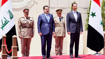 بشار الأسد يقف إلى جانب رئيس الوزراء العراقي خلال مراسم الاستقبال في قصر الشعب بدمشق – 16 تموز 2023 (رويترز)