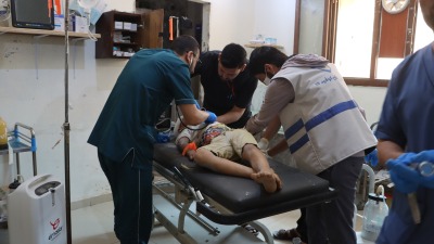 كادر طبي يُسعف طفل جريح بعد قصف النظام وروسيا على بلدة البارة (الدفاع المدني السوري)