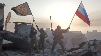 ثلة من مقاتلي مجموعة فاغنر يرفعون العلم الروسي وعلم مجموعتهم في منطقة غير معروفة في خضم الغزو الروسي لأوكرانيا- تاريخ الصورة: 20 أيار 2023