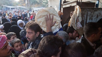 توزيع الخبز عبر البطاقة الإلكترونية في أحد أفران دمشق (Getty)