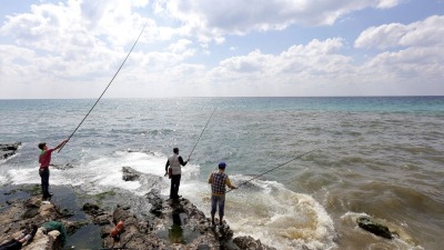صيادون سوريون يقفون على أحد الشواطئ القريبة من جزيرة قبرص