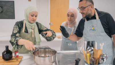 رامي وأسرته وهم يعدون طبق اليالنجي السوري في مطبخ مركز موزاييك