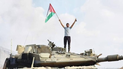 شاب فلسطيني يرفع العلم الفلسطيني فوق دبابة إسرائيلية في إحدى مستوطنات غلاف غزة (نشرتها يديعوت أحرونوت)