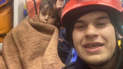 فريق الانقاذ مع الطفل السوري عقب انقاذه من تحت الأنقاض