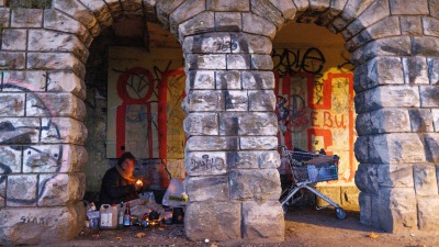 مشرد يجهز مكانًا للنوم تحت أقواس في برلين، ألمانيا، 10 نوفمبر