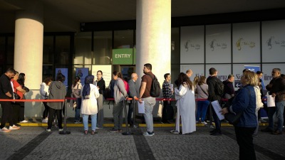 أشخاص ينتظرون دورهم في مركز طلبات التأشيرة في إسطنبول (AP)