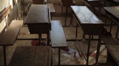 آثار دماء الأطفال تحت المقاعد الدراسية بمدرسة الشهداء في قرية آفس شرقي إدلب - 2 كانون الأول 2023 (الدفاع المدني السوري)