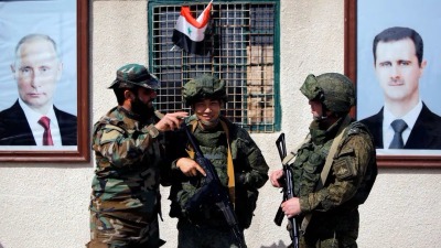 جنديان روسيان إلى جانب عنصر من قوات النظام عند نقطة تفتيش قرب دمشق - 2 آذار 2018 (رويترز)
