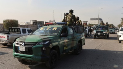 قوات الأمن العراقية تجلس على مركبات في أحد الشوارع بعد هجوم بطائرة بدون طيار على مقر للميليشيا المدعومة من إيران في بغدا