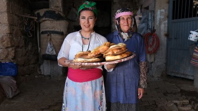 الطاهية التركية ديمير وهي تحمل أحد أنواع المعجنات التقليدية وبجانبها امرأة من ماردين وكلتاهما ترتديان الزي التقليدي للمنطقة