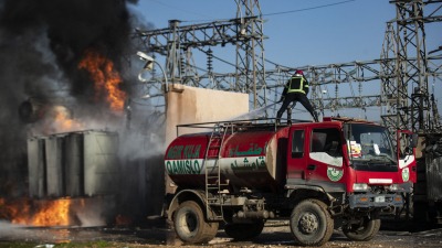 إخماد حريق في محطة كهرباء بمدينة القامشلي من جراء غارات يعتقد أنها تركية - 15 كانون الثاني 2024 (AFP)
