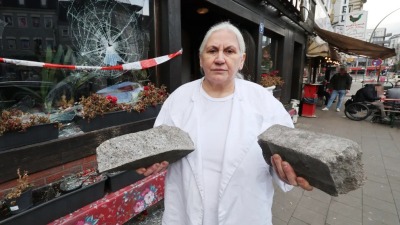 صاحبة المطعم تحمل الأحجار التي رماها السوري على متجرها 