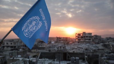 ناشطون ينكّسون علم الأمم المتحدة فوق مبانٍ منهارة جراء الزلزال في سوريا (مواقع التواصل)